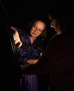 Two students looking at a pre-lit board.