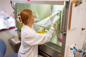 Ashley Monks, dressed in a lab coat, performing a research task.