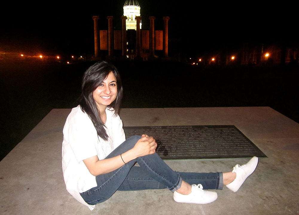 Kanwal Haq posing for a picture in front of the Mizzou Columns.