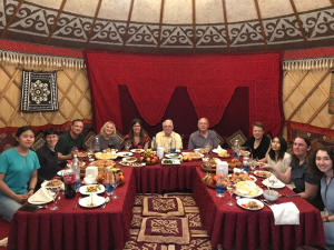 A group of individuals smiling for a picture before eating a meal.