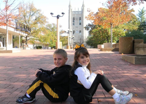 Two young kids posing for a picture in front of Memorial Union.