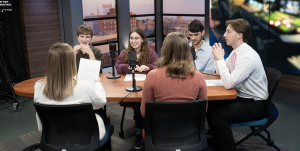 A group of students sitting around a table talking.