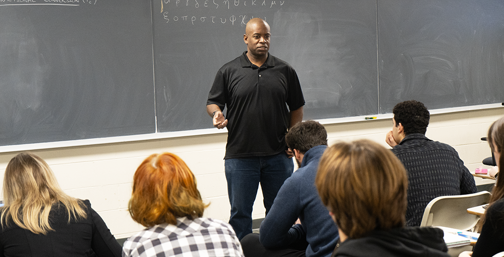 Reginald Rogers teaching to a classroom full of students.