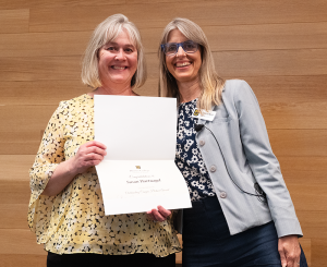 Susan Hartnagel, pictured on the left, smiles for the camera while holding an award. She is joined by Catherine Rymph.