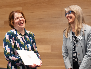 Katie Essing, pictured on the left, laughs after receiving an award from Catherine Rymph.