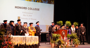 A group of individuals laughing during a graduation ceremony.