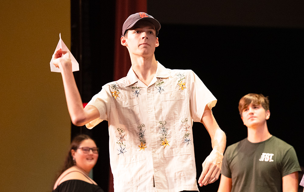 A student throwing a paper airplane.