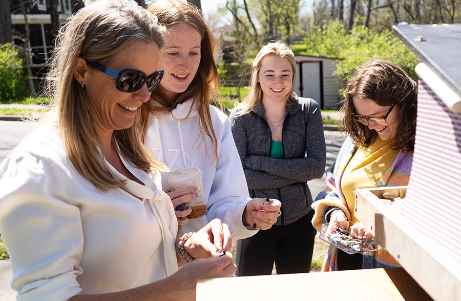 A group of students and a professor smiling while working on a project.