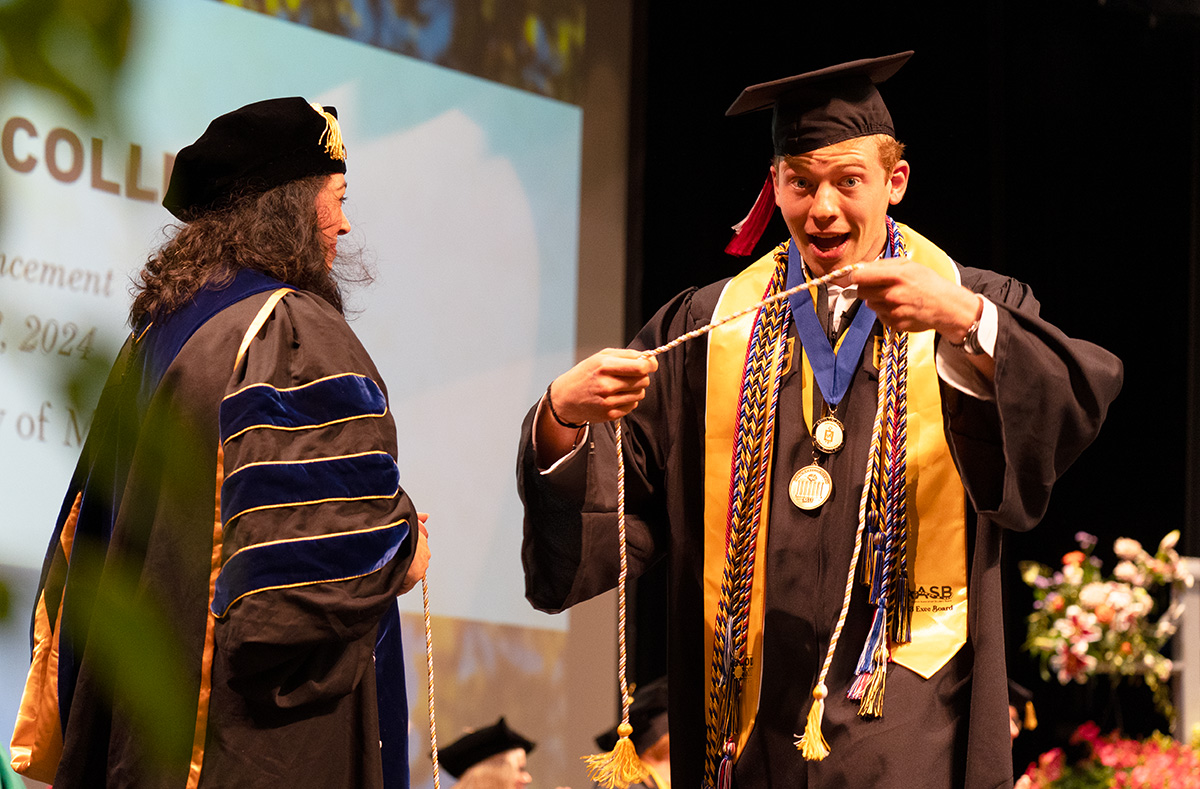 A student celebrating receiving the Honors cord during the Honors College commencement ceremony.