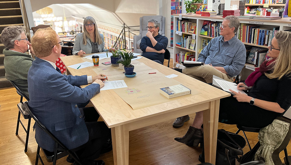 A group of professors sitting around a table talking.