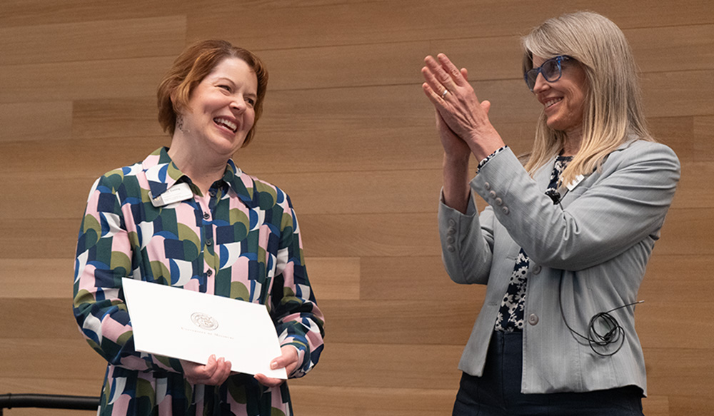 Catherine Rymph clapping after giving an award to Katie Essing.