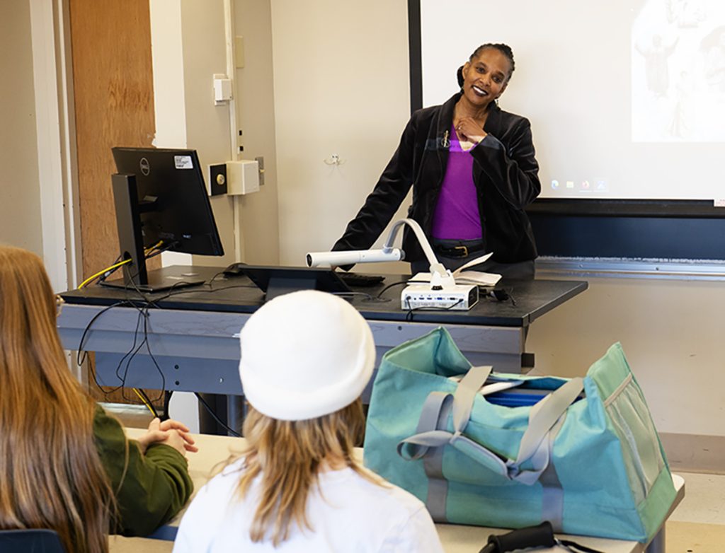 Maya Gibson standing in front of her students, teaching a class.