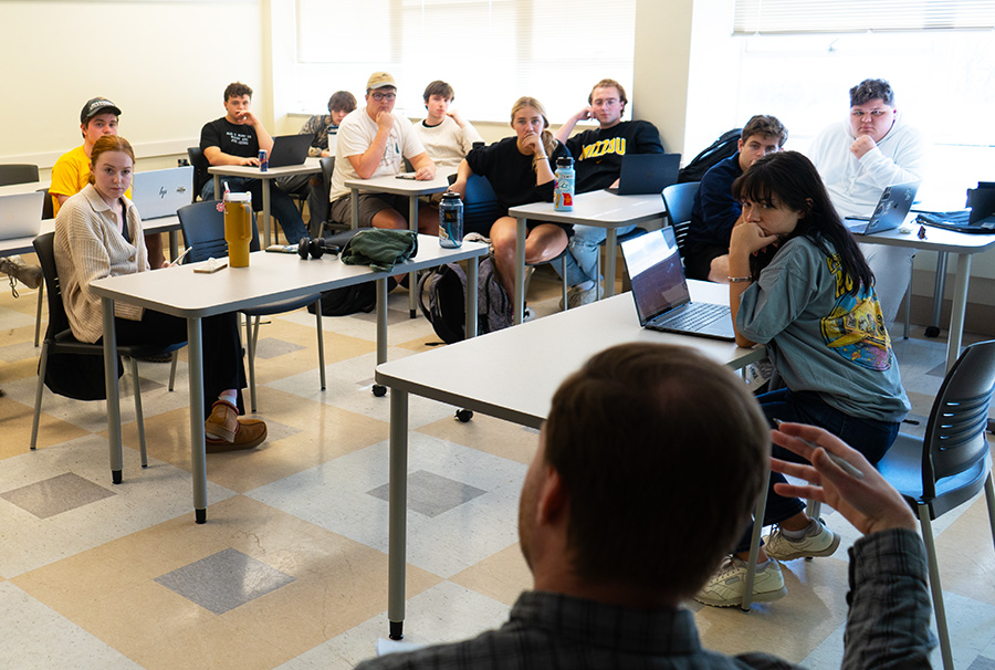 Students listening to their professor speak.