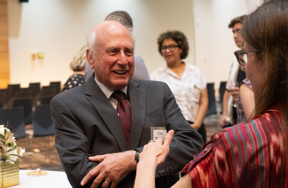 Ted Tarkow smiling while talking to an individual.