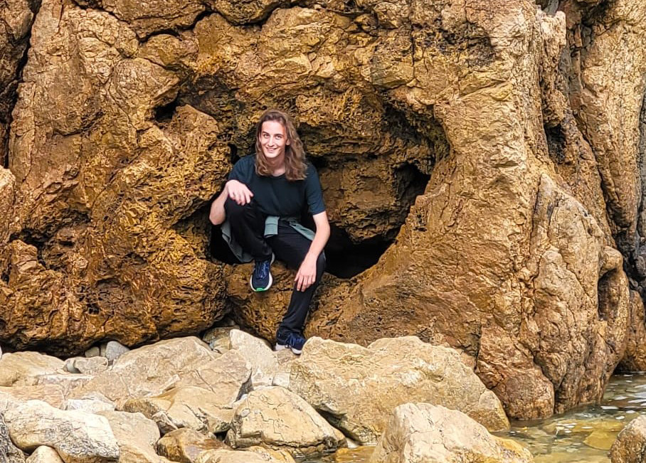 Jasper Holland posing for a picture while sitting in a cave.