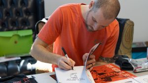 Andrew Fialka signing one of his graphic history books.