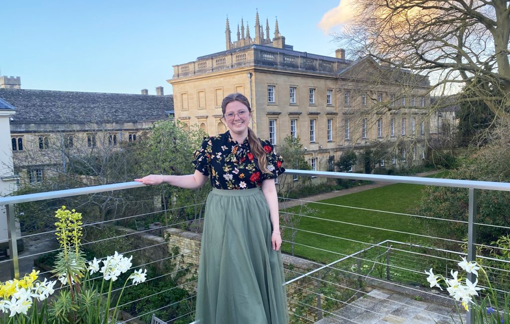 Elise Milburn smiling and posing for a picture in front of a historic landmark.
