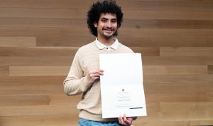 Isaac Yontz smiling while holding a certificate.