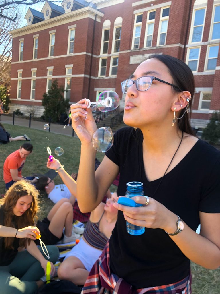 Maya Bowman blowing bubbles with other students.