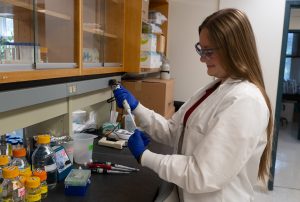 Caitlin Mattingly performing a research task while in a laboratory.