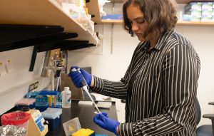 Alexandra Renoe performs a research task in a laboratory.