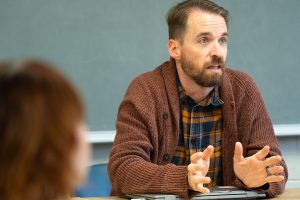 A professor talking with students during class.