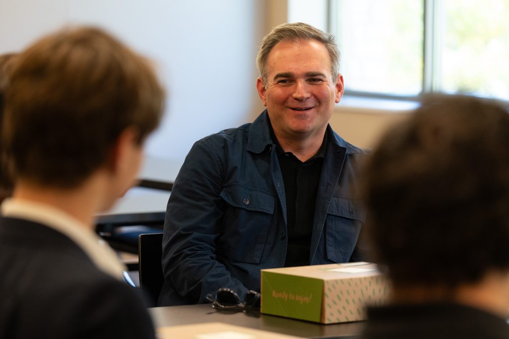 Brent Steele smiling while talking with students.