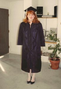 Heather Humphrey posing for a graduation photo while wearing a cap and gown.
