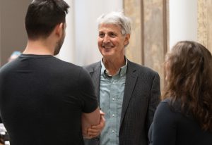 David Schenker smiling while talking to two former students.