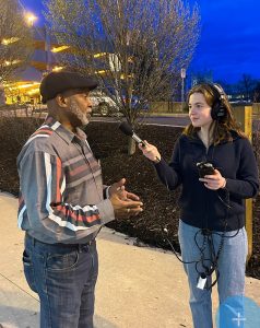 Lilley Halloran interviewing an adult at night.