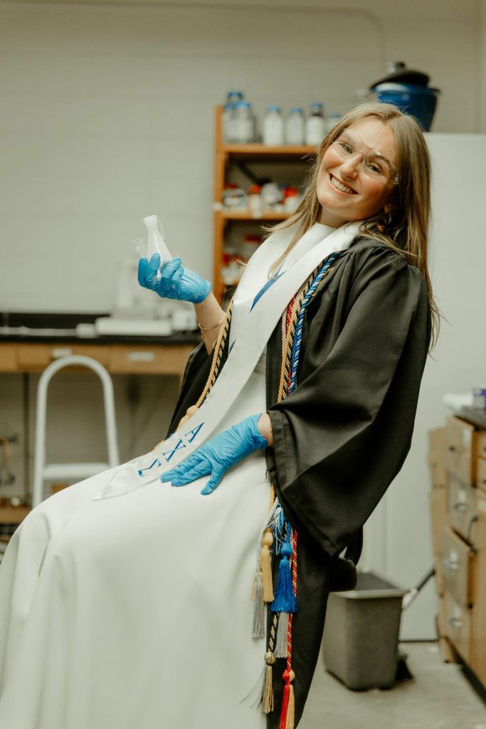 Nora Pryor standing in a laboratory and posing for a senior photo.