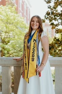 Nora Pryor standing outside and posing for a senior photo.