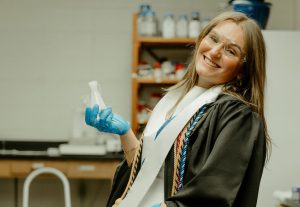 Nora Pryor standing in a laboratory and posing for a senior photo.