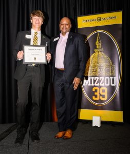 Two individuals smiling for a photo during an awards ceremony.