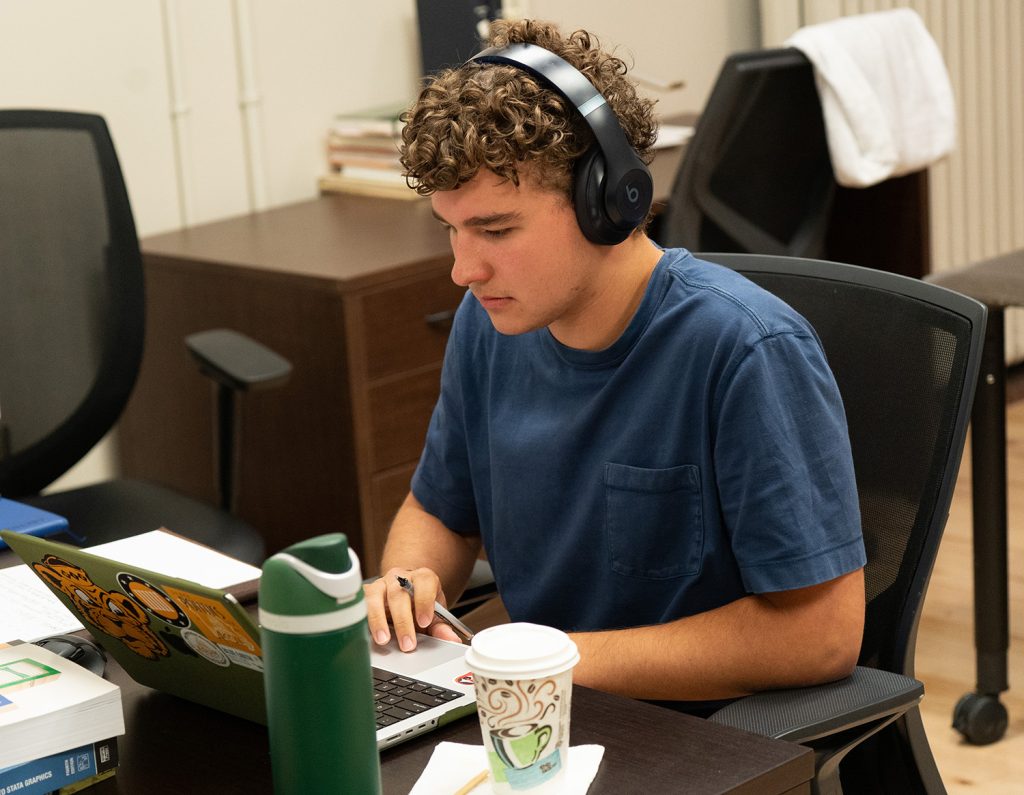 Henry Birkmeier sitting and working on a laptop.