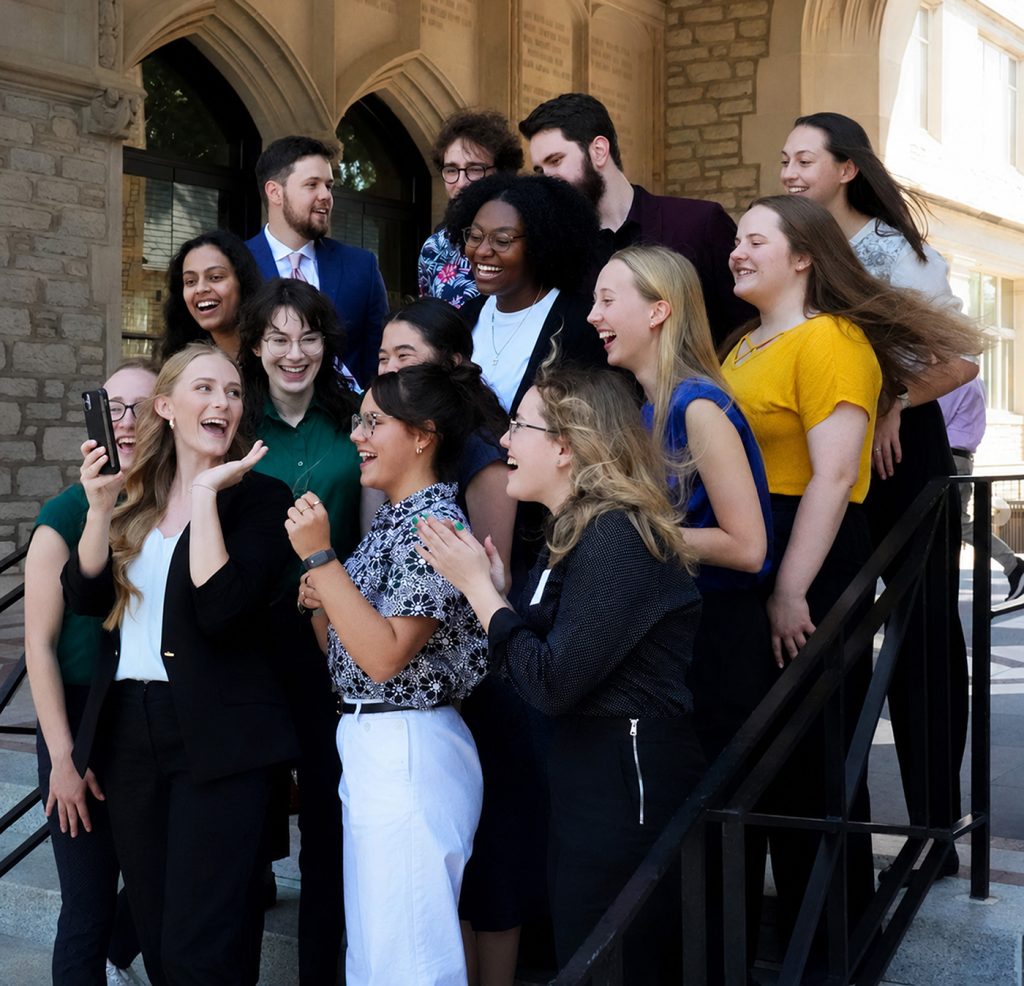 A group of students smiling and laughing while taking a selfie.