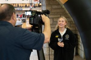 Megan Mesikapp conducting an on-camera interview with a reporter.