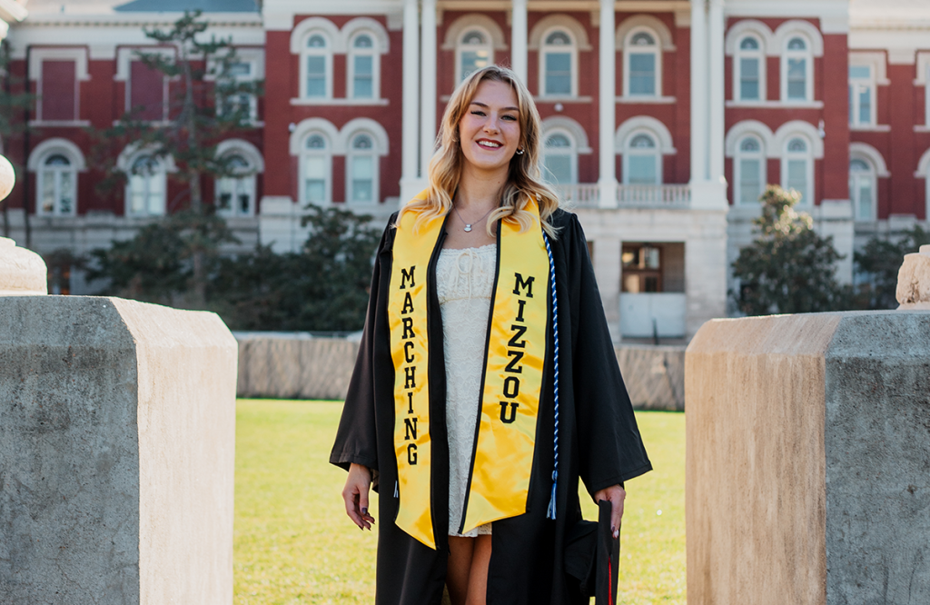 Anna Kochman poses for a graduate picture in front of Jesse Hall.