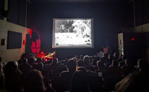 A large group of students in a theater watching a movie.