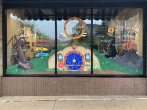 Columbia Art League window painted with the words “Home is behind us, the world is ahead”